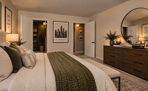 A bedroom with a large bed and a mirror on the wall.