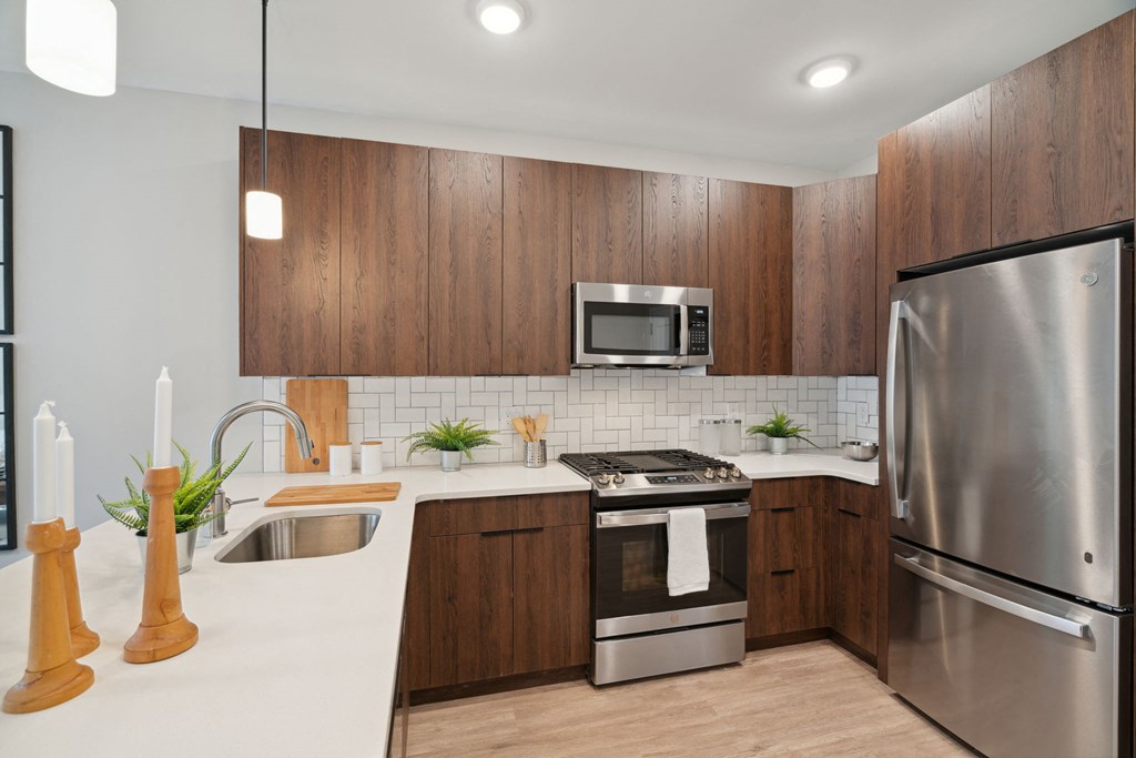 a modern kitchen with stainless steel appliances and wooden cabinets
