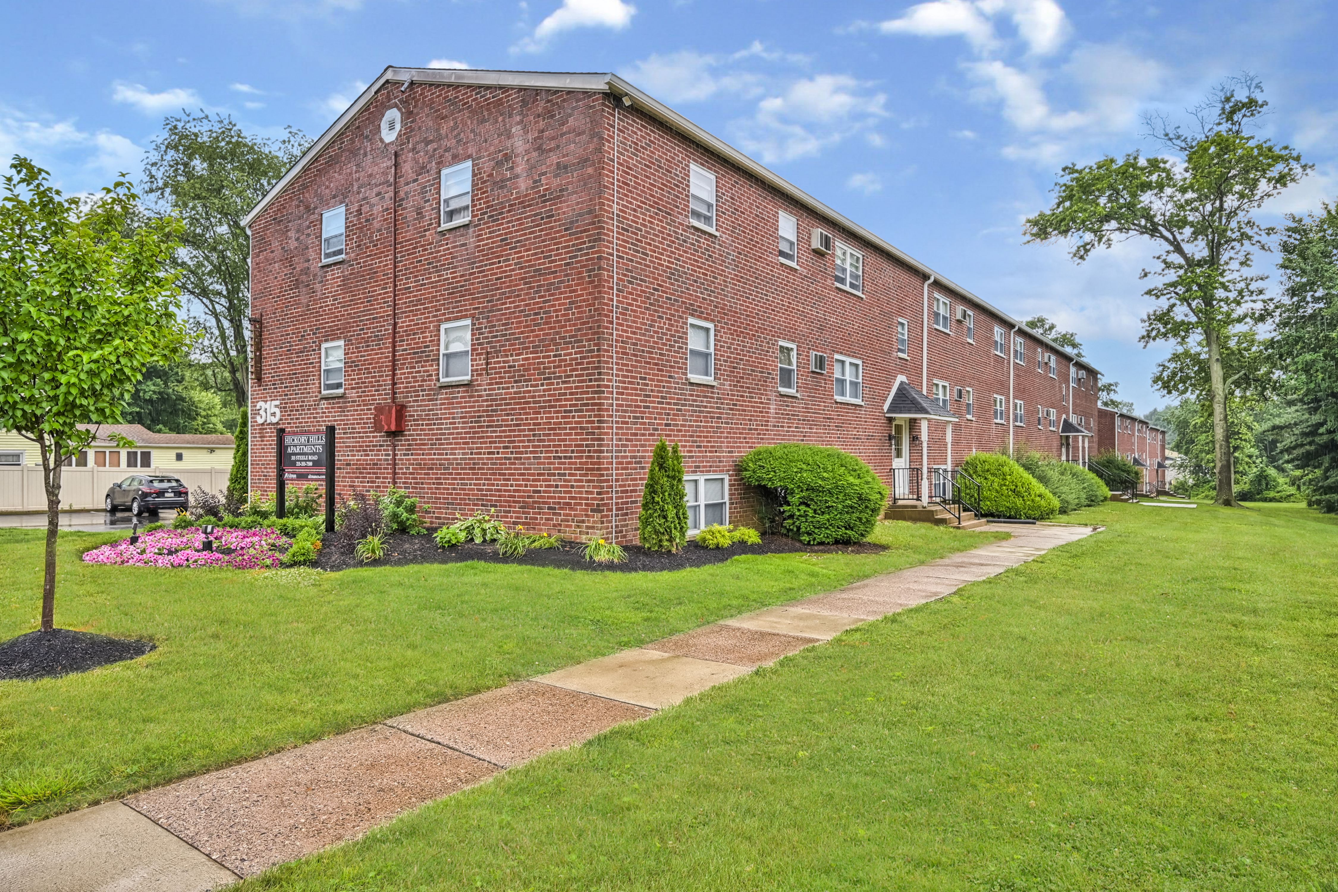 A red brick building with a green lawn in front.