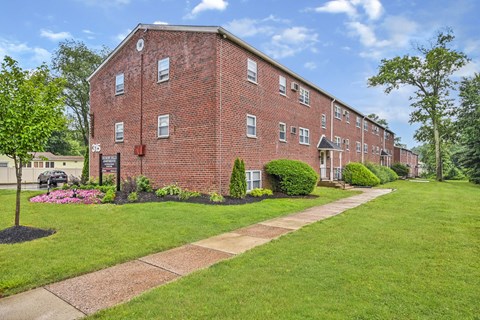 A red brick building with a green lawn in front.
