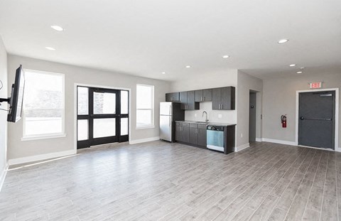 an empty room with a kitchen and a door