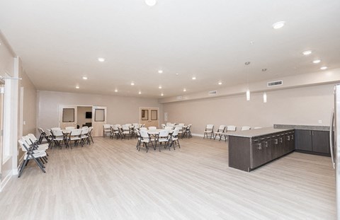 the multipurpose room with tables and chairs and a kitchen