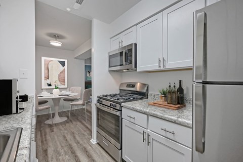 A kitchen with white cabinets and stainless steel appliances.