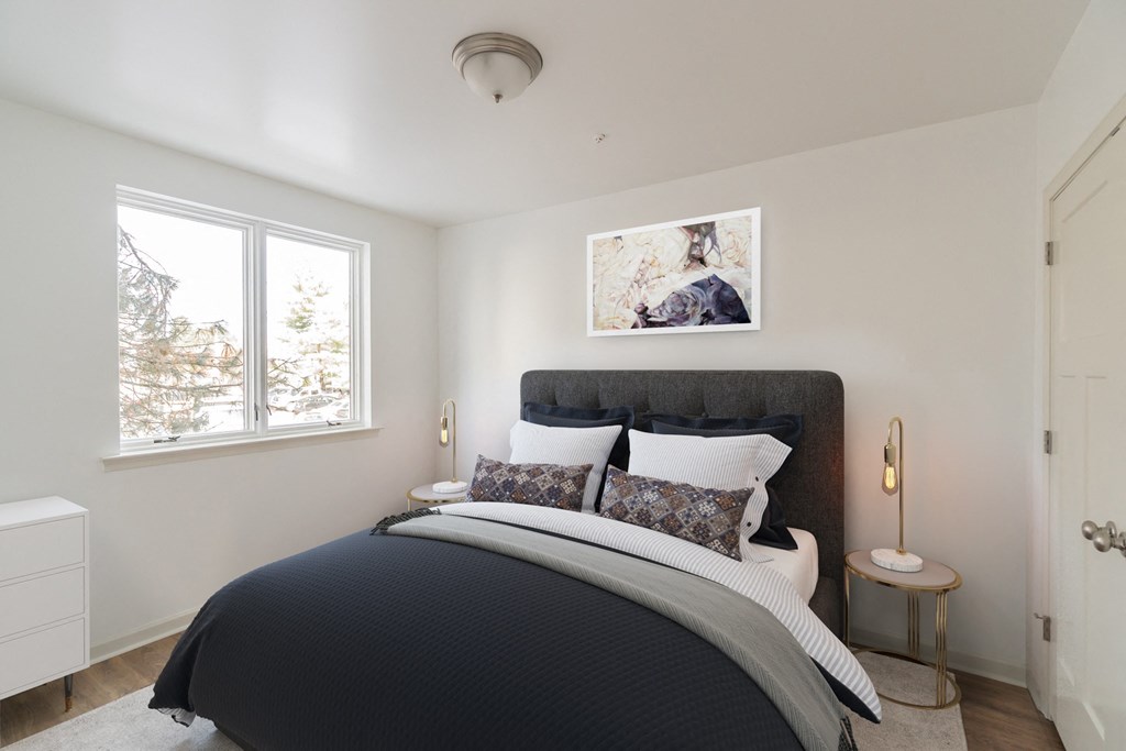 a bedroom with a bed and two windows