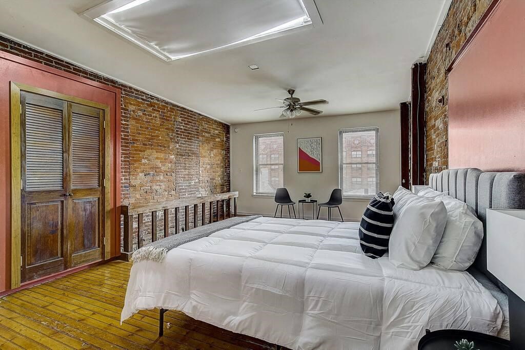 a bedroom with a large bed and a brick wall