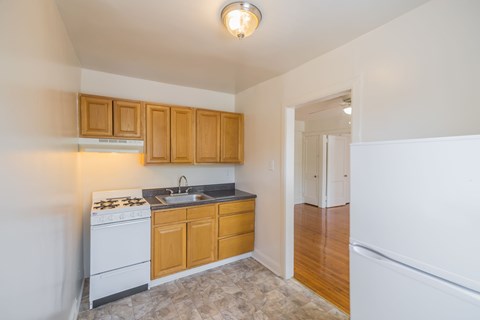 A kitchen with wooden cabinets and a white stove top oven.