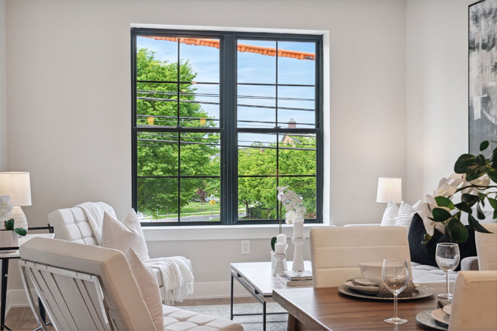 a living room with a large window and a table and chairs