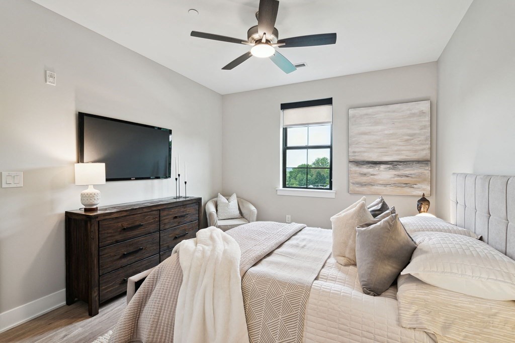 an open bedroom with two beds and a ceiling fan