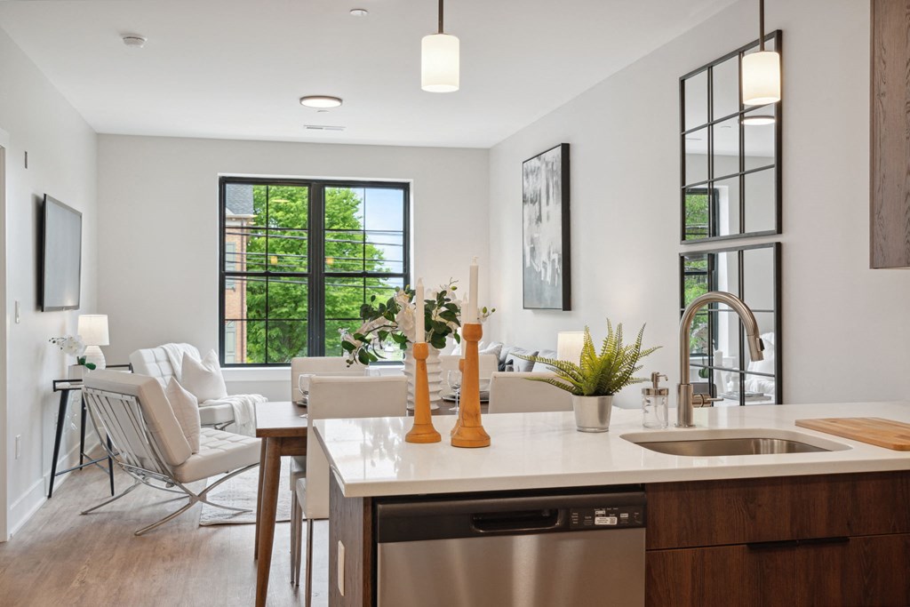 an open kitchen and living room with a table and chairs and a sink