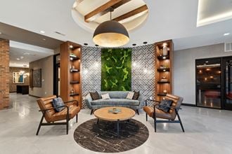 a lobby with a couch and chairs and a green wall