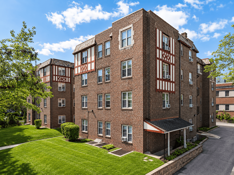 A large brick building with a red and white striped building in the background.