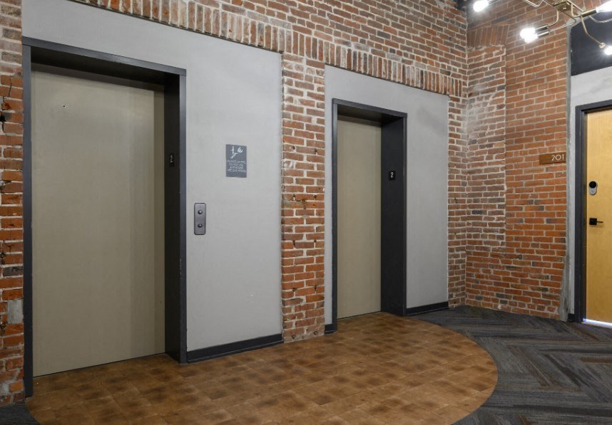 a room with two doors and a brick wall