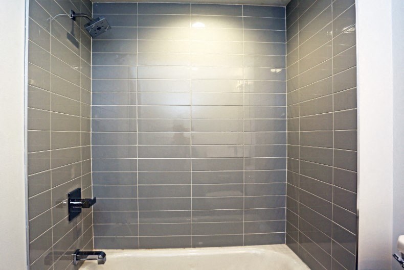 a tiled bathroom with a tub and a shower