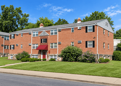 A red brick building with a red awning and a chimney.