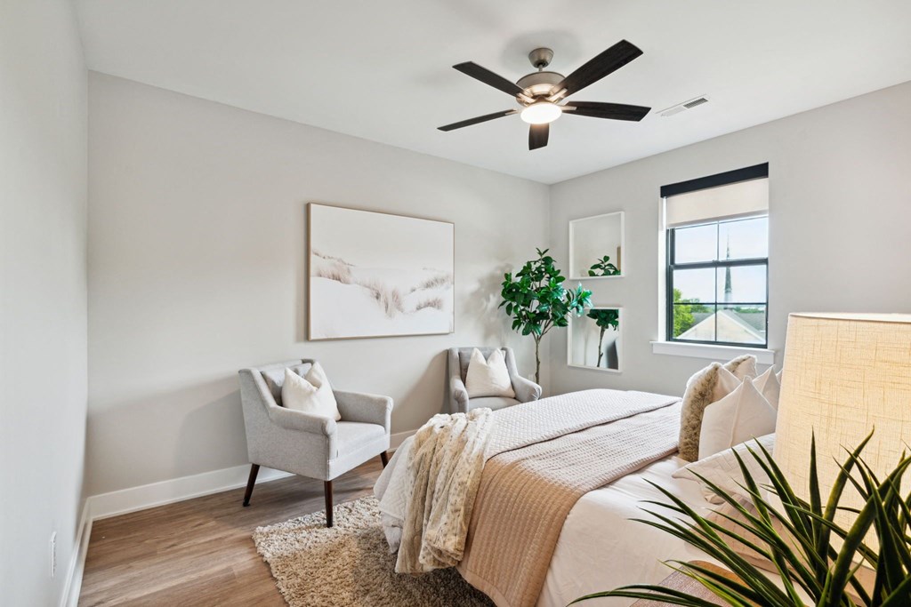 an open bedroom with a bed and a ceiling fan