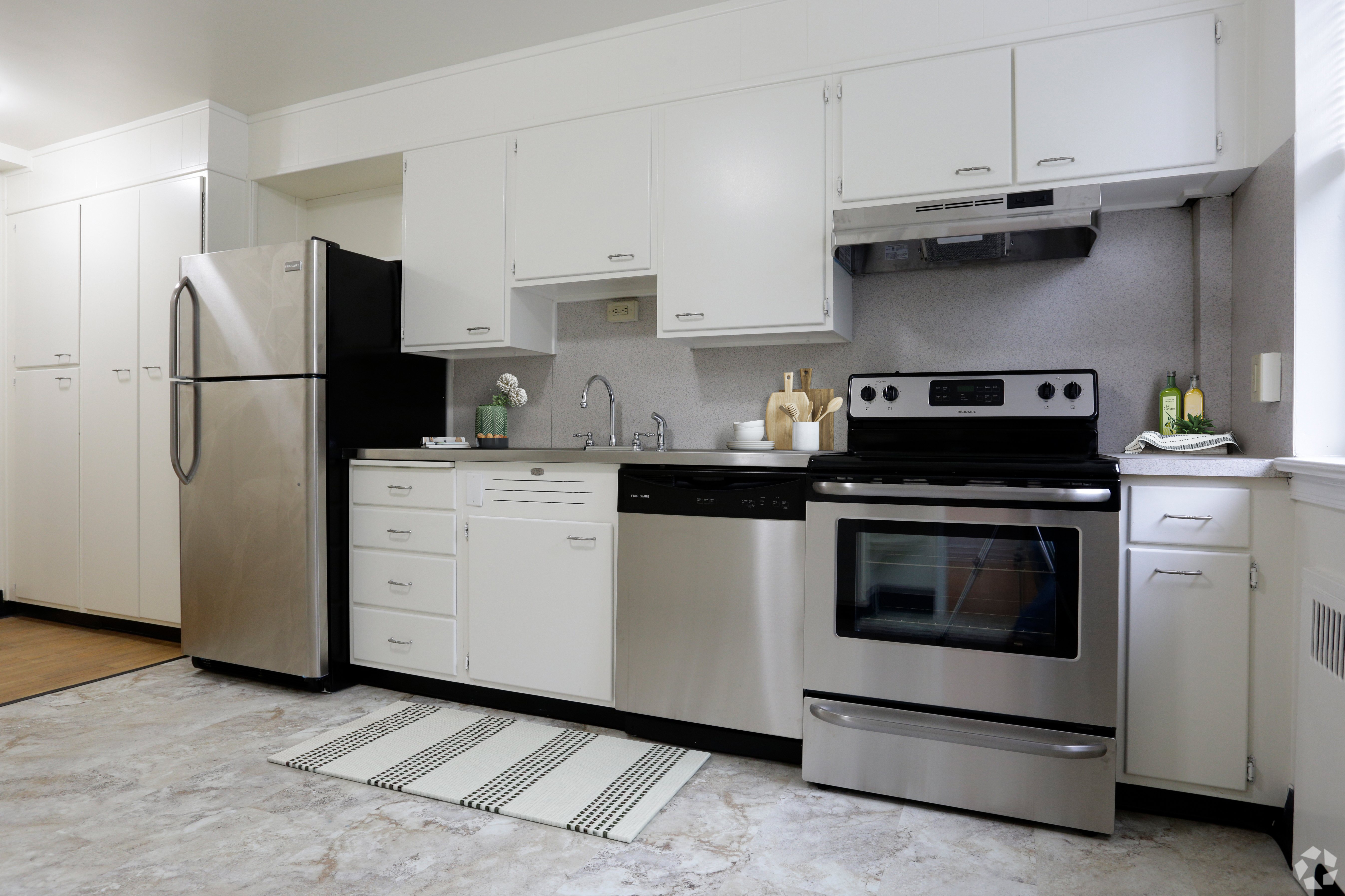 A modern kitchen with stainless steel appliances and white cabinets.