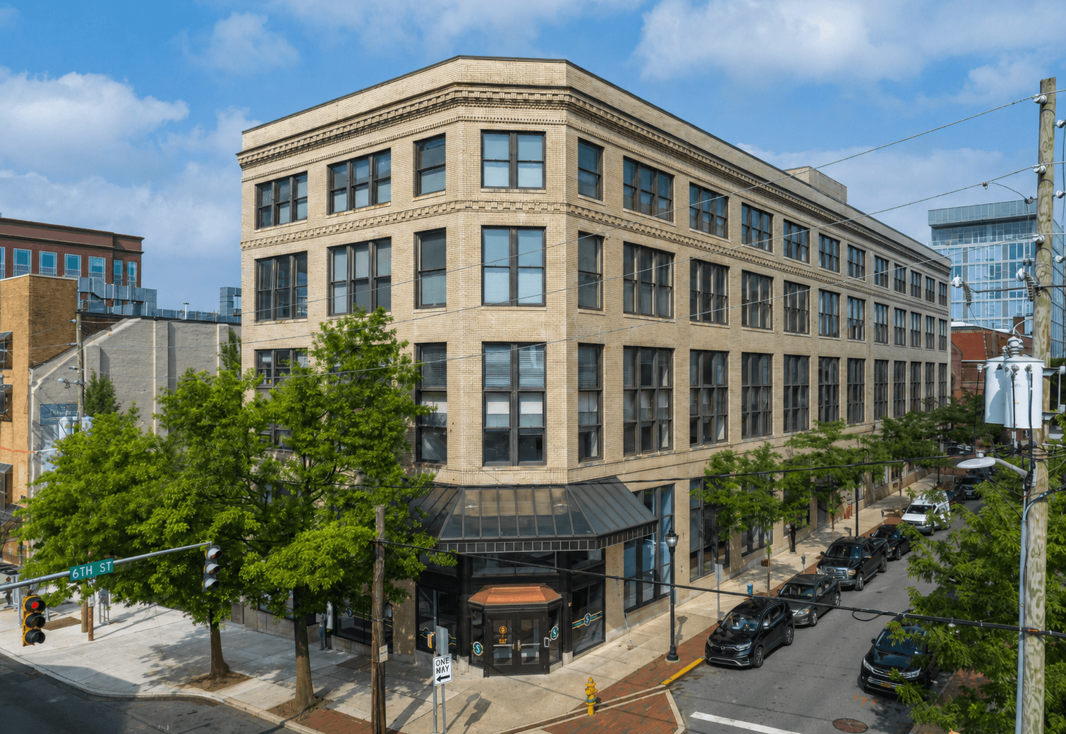 A street view of a large building with a parking lot in front.