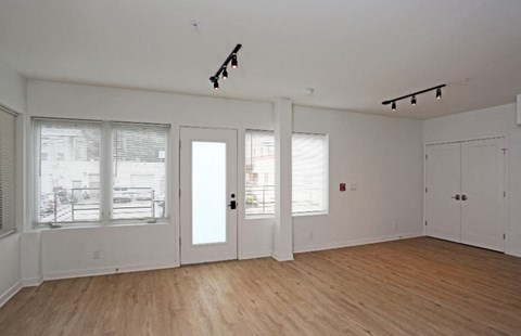 an empty living room with white walls and a wood floor