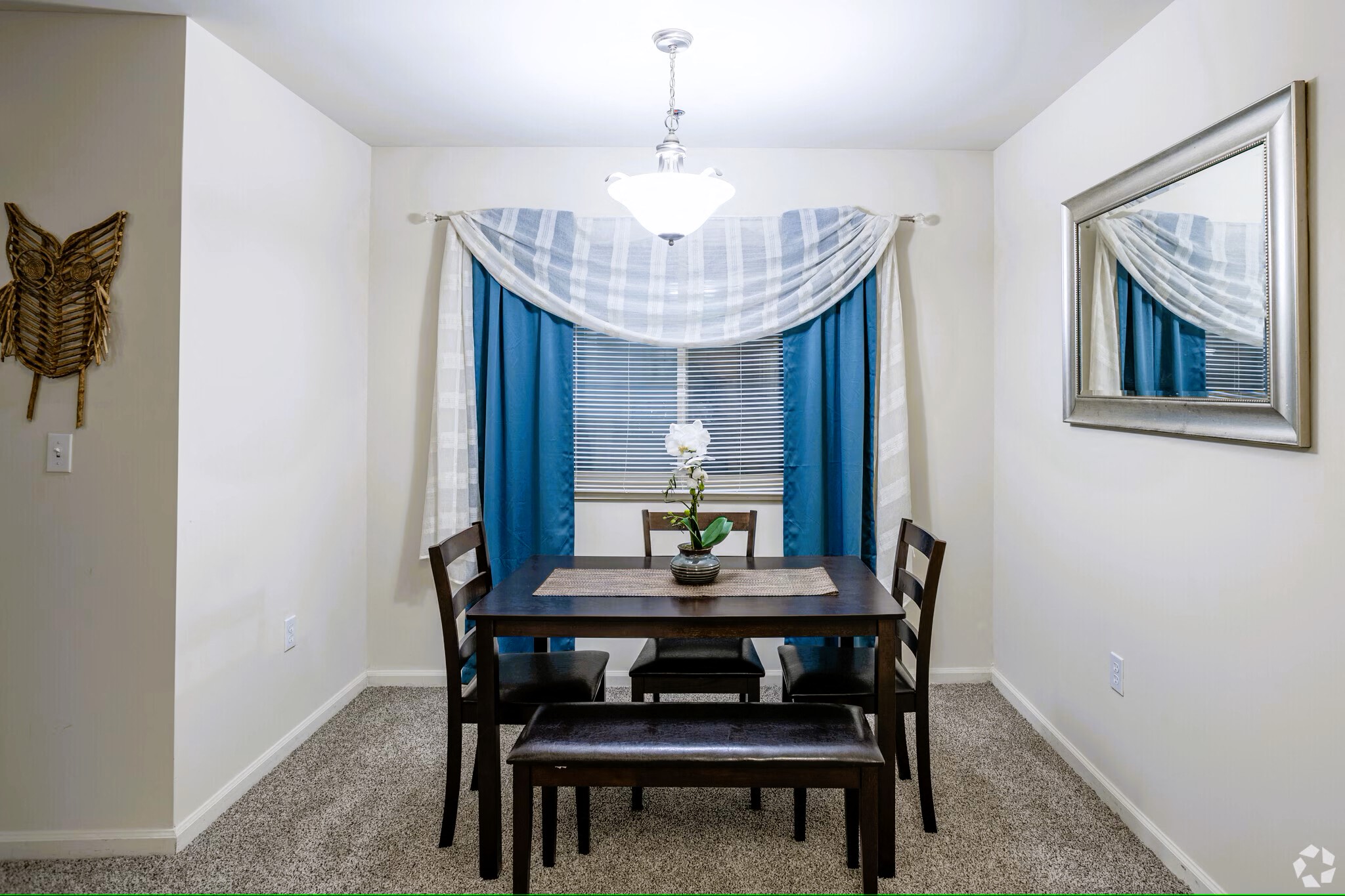 A dining room with a table and chairs.