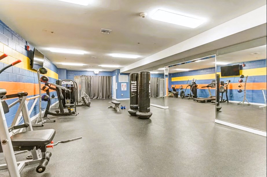 A gym with a variety of equipment including weights and machines.