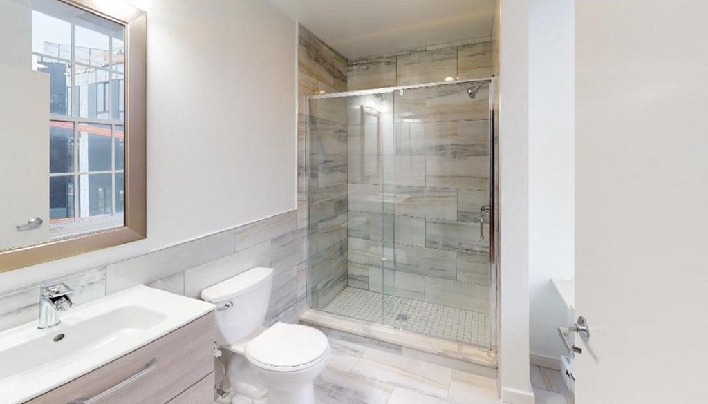 a bathroom with a shower and a toilet and a sink