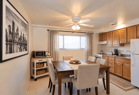A kitchen with a dining table and chairs.