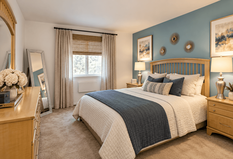 A bedroom with a large bed, a dresser, and a mirror.