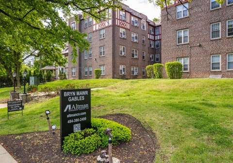 A sign for Bryn Mawr Gables Apartments is in the foreground of a grassy area.