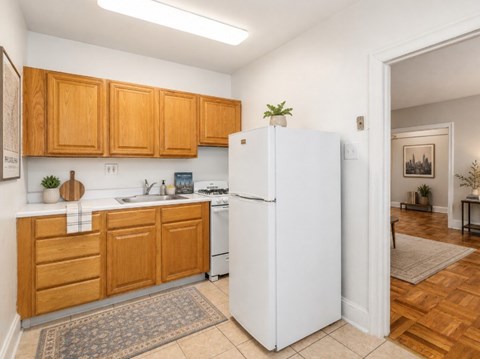 A kitchen with wooden cabinets and a white refrigerator.
