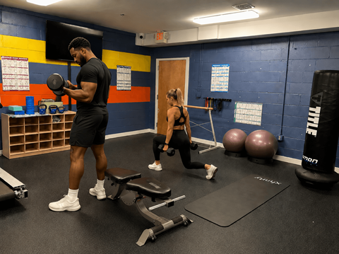 A man and a woman are exercising in a gym.