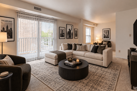 A living room with a large couch, a coffee table, and a lamp.