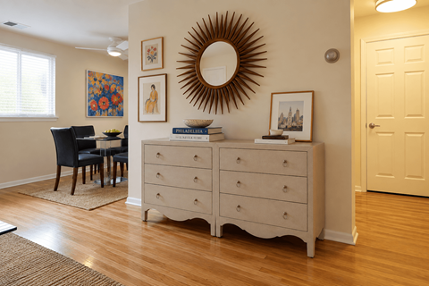 A white dresser with a mirror above it in a room.