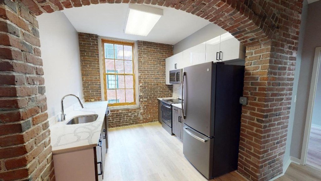 an empty kitchen with a refrigerator and a sink