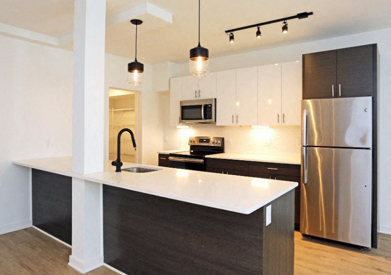 a kitchen with stainless steel appliances and a white counter top