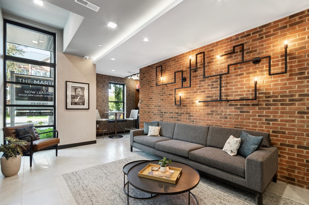 a living room with a brick wall with a couch and a coffee table
