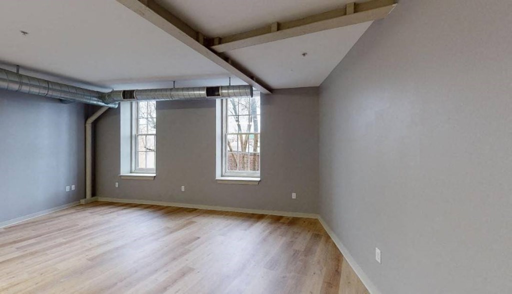 an empty room with a wood floor and a window
