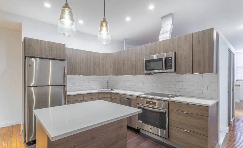 a kitchen with stainless steel appliances and white counter tops