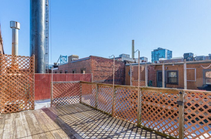 the roof deck of a building with a city in the background