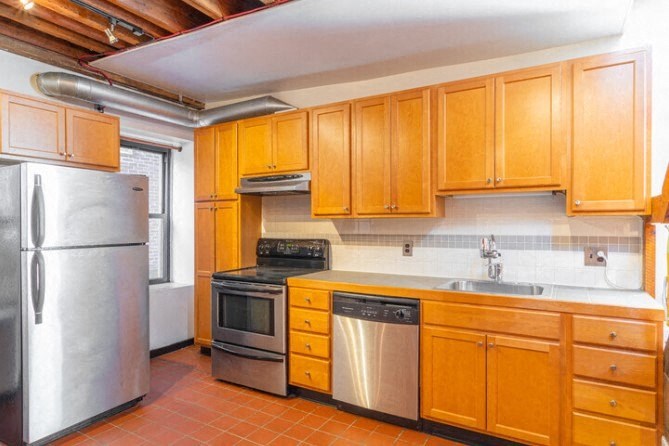 a kitchen with wooden cabinets and stainless steel appliances