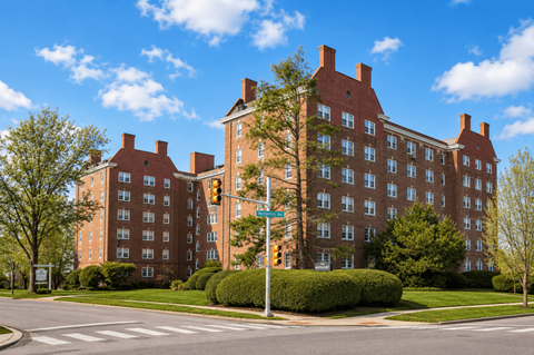 A large red brick building with a green traffic light in front of it.