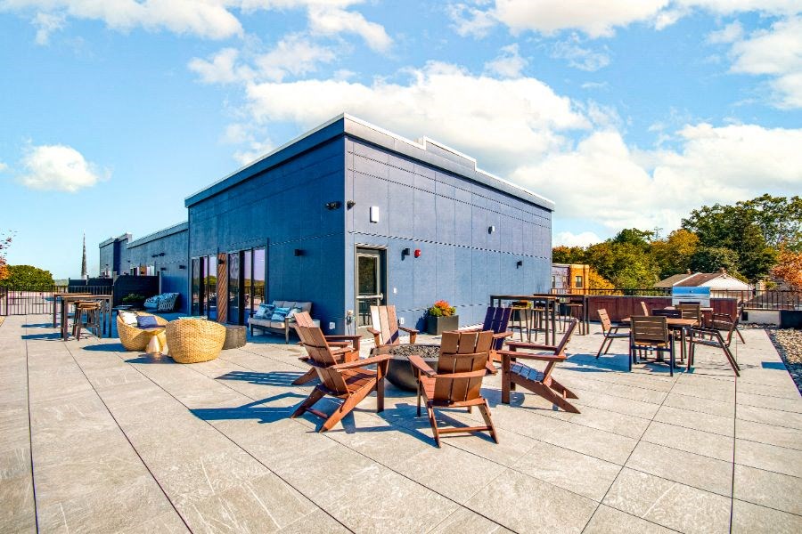 a patio with tables and chairs outside of a blue building