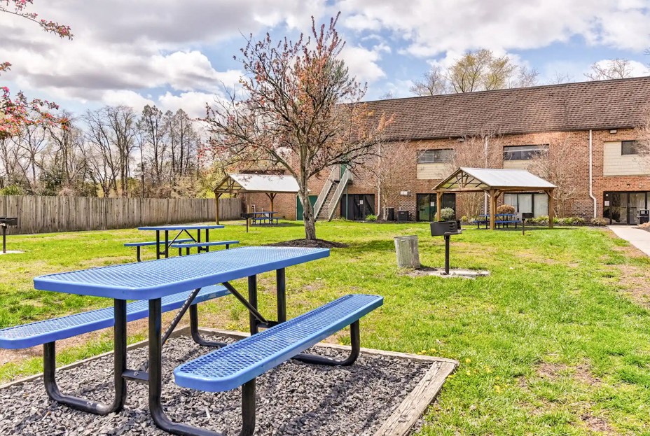 A blue picnic table and bench in a park.