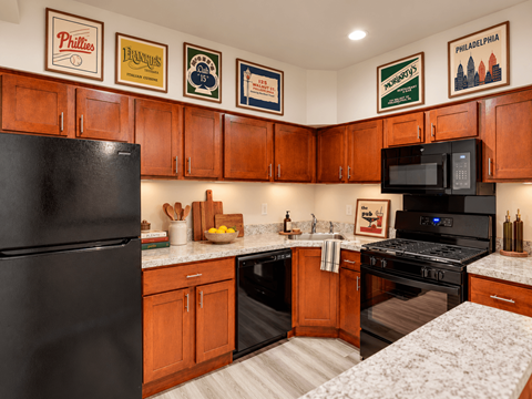 A kitchen with wooden cabinets and a black refrigerator.