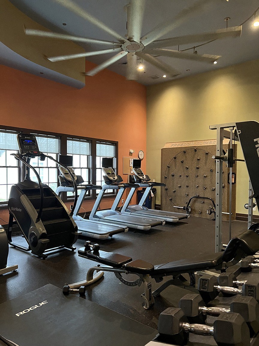 Fitness center with rotating climbing wall