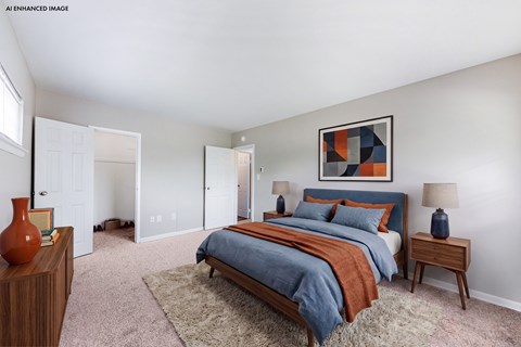 A bedroom with a bed, nightstands, and a rug.