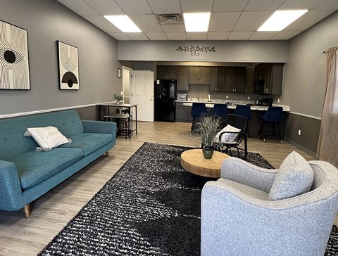 A living room with a blue couch and a grey armchair.
