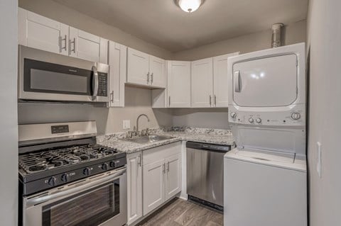 A kitchen with white cabinets and a microwave above the stove.