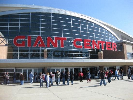 a group of people standing outside of a giant center building