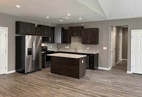 a kitchen with stainless steel appliances and dark cabinets