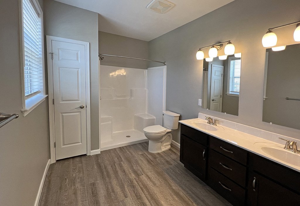 a bathroom with a shower toilet and sink and a mirror